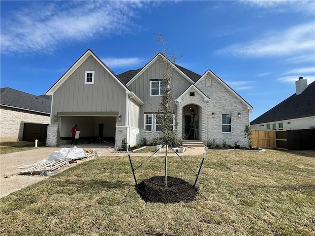 view of front facade featuring board and batten siding, a front yard, fence, and an attached garage