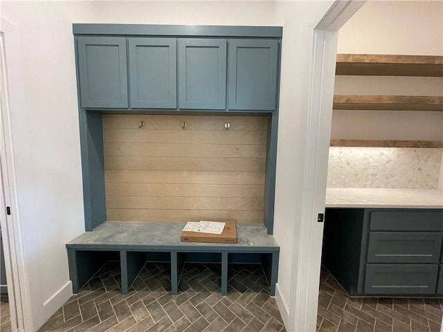 mudroom with brick floor and baseboards