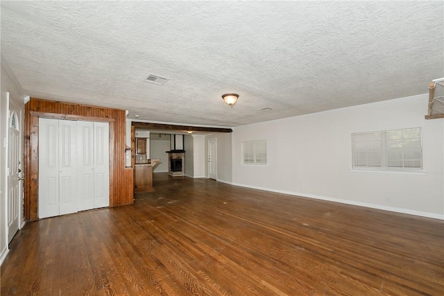 unfurnished living room with dark hardwood / wood-style flooring and a textured ceiling