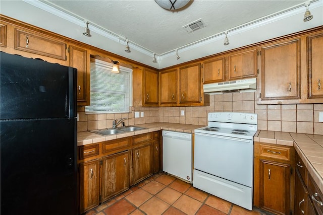 kitchen featuring tile counters, decorative backsplash, white appliances, and crown molding