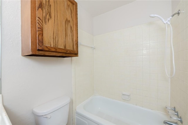 bathroom featuring toilet and tiled shower / bath