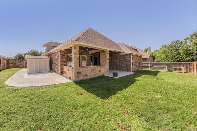 back of house featuring a patio area, roof with shingles, and brick siding
