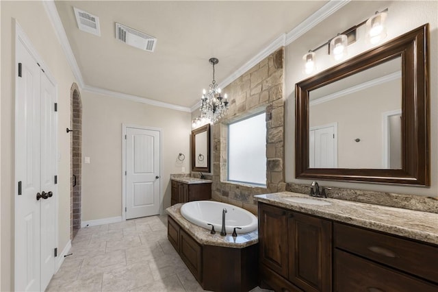 full bath with crown molding, a chandelier, a garden tub, two vanities, and baseboards