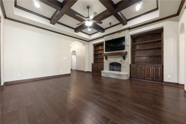 unfurnished living room featuring arched walkways, a ceiling fan, coffered ceiling, baseboards, and beam ceiling