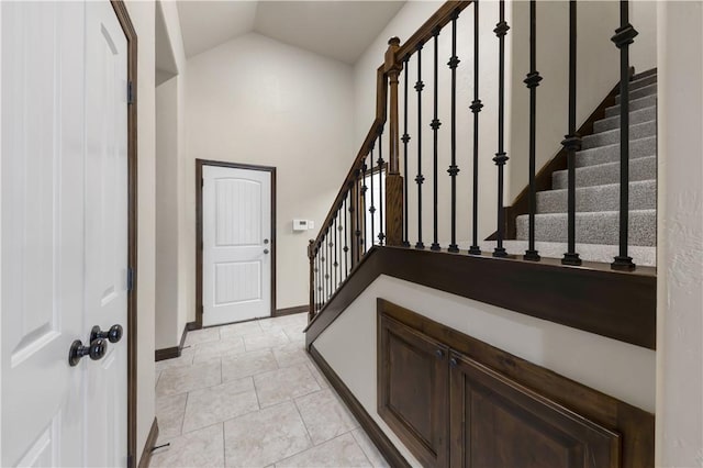 stairs featuring vaulted ceiling and baseboards