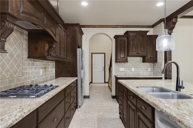 kitchen featuring stainless steel appliances, a sink, dark brown cabinetry, hanging light fixtures, and recessed lighting