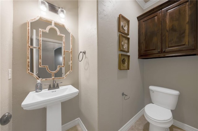 bathroom with toilet and baseboards
