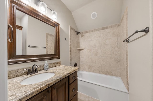 bathroom featuring vaulted ceiling, vanity, and bathing tub / shower combination