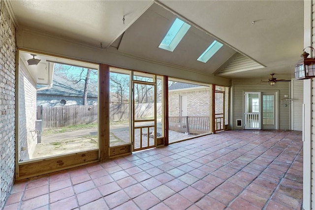 unfurnished sunroom featuring ceiling fan and vaulted ceiling with skylight