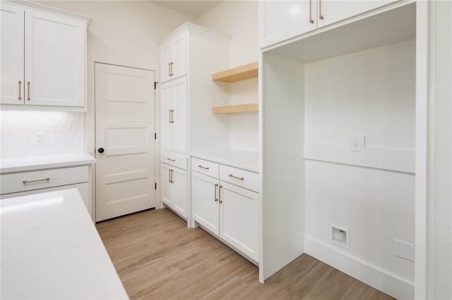 2802 Spector Dr, Bryan, TX 77808 - kitchen featuring light wood-type flooring, light countertops, white cabinetry, tasteful backsplash, and open shelves