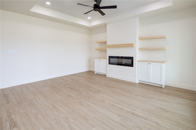 2802 Spector Dr, Bryan, TX 77808 - unfurnished living room featuring a raised ceiling, ceiling fan, light wood finished floors, a glass covered fireplace, and recessed lighting