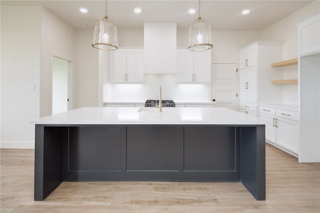 2802 Spector Dr, Bryan, TX 77808 - kitchen featuring a large island with sink, light countertops, white cabinets, backsplash, and hanging light fixtures