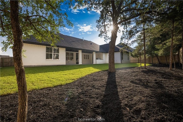 rear view of property featuring a lawn