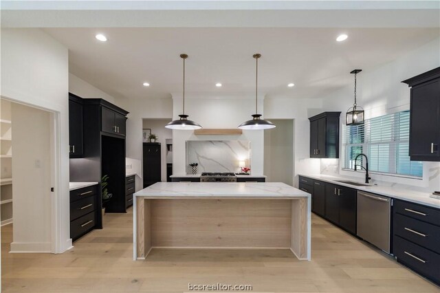 kitchen featuring pendant lighting, dishwasher, a center island, and light hardwood / wood-style floors