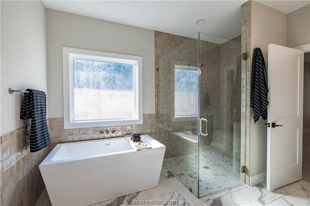 bathroom with tile walls and plus walk in shower