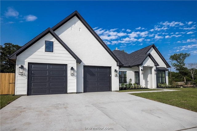 modern farmhouse style home featuring a front lawn and a garage