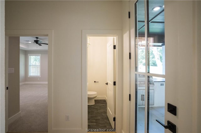 hall featuring dark colored carpet