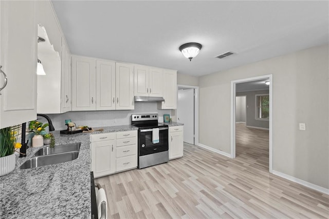 907 Barnhill St, Brenham, TX 77833 - kitchen with stainless steel electric range, under cabinet range hood, white cabinetry, and light wood-type flooring