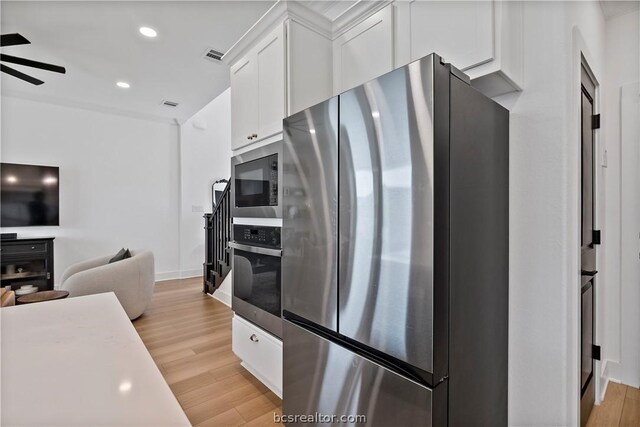 kitchen featuring white cabinetry, ceiling fan, light hardwood / wood-style floors, and appliances with stainless steel finishes