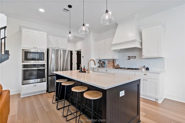 kitchen with custom exhaust hood, a kitchen breakfast bar, white cabinetry, and stainless steel appliances