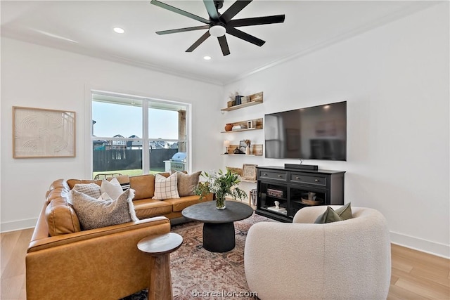 living room featuring light hardwood / wood-style flooring, ceiling fan, and ornamental molding