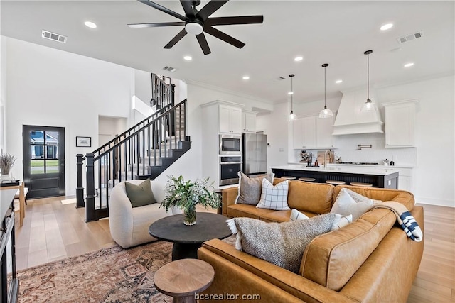 living room with ceiling fan and light wood-type flooring