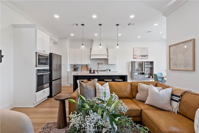 living room featuring light hardwood / wood-style floors and crown molding