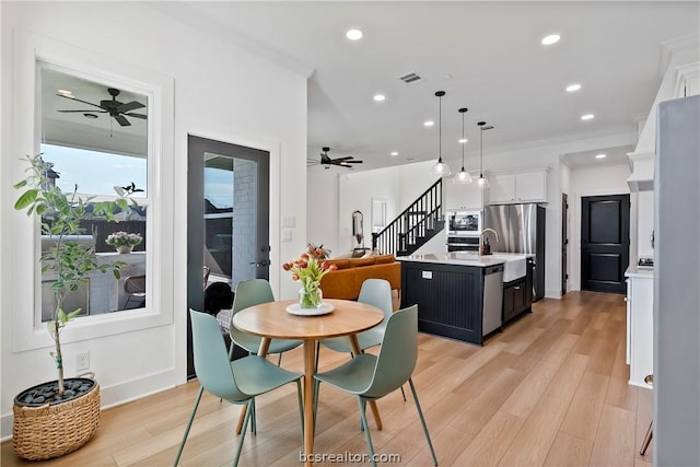 dining area with light hardwood / wood-style floors, ceiling fan, and ornamental molding