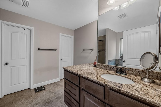 full bathroom with vanity, baseboards, visible vents, and walk in shower