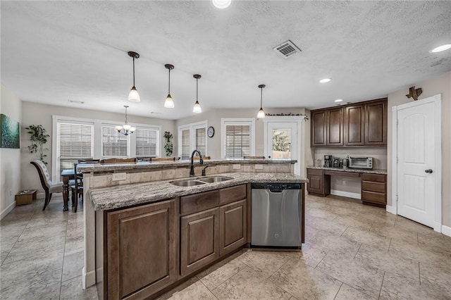 kitchen with visible vents, a toaster, a center island with sink, dishwasher, and a sink