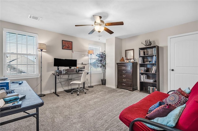 office space featuring visible vents, ceiling fan, baseboards, and carpet