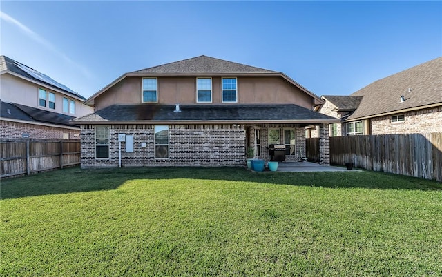 back of property featuring stucco siding, a lawn, a patio, a fenced backyard, and a shingled roof