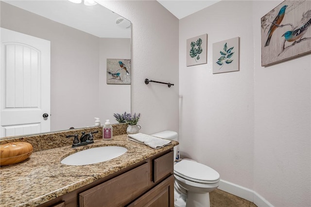 half bath with vanity, tile patterned floors, toilet, and baseboards