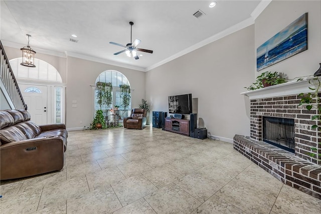 living area with crown molding, a brick fireplace, baseboards, and visible vents