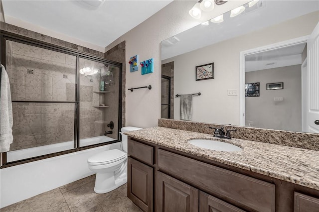 bathroom with vanity, toilet, combined bath / shower with glass door, and tile patterned flooring