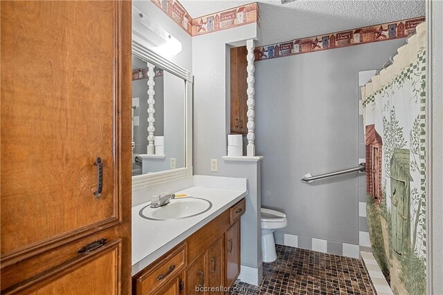 bathroom featuring tile patterned flooring, vanity, a textured ceiling, and toilet