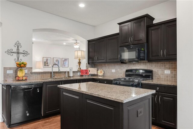 kitchen with a kitchen island, black appliances, sink, backsplash, and kitchen peninsula