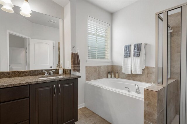 bathroom featuring tile patterned flooring, vanity, separate shower and tub, and a chandelier