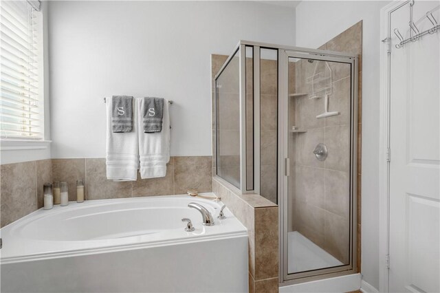 bathroom featuring shower with separate bathtub