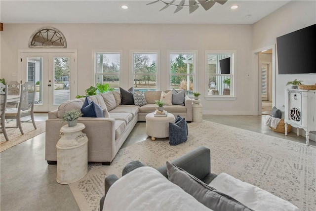 living area featuring baseboards, french doors, recessed lighting, and finished concrete floors