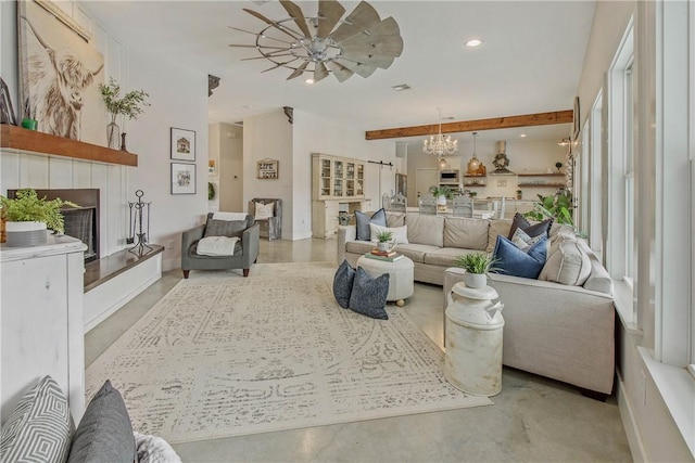 living area featuring a notable chandelier, recessed lighting, concrete floors, a fireplace, and beamed ceiling