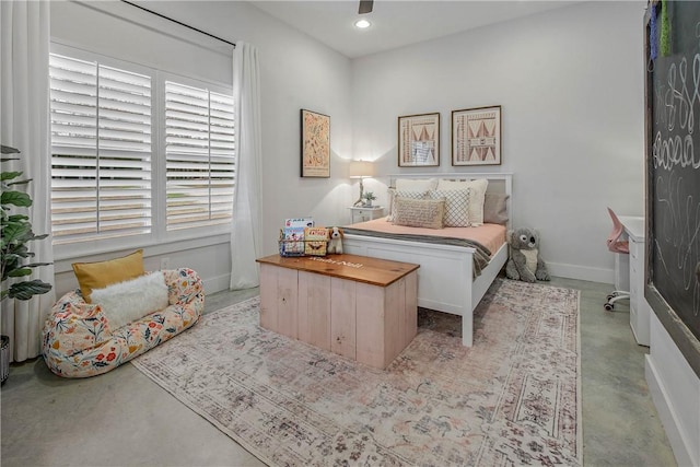 bedroom with concrete floors, baseboards, and recessed lighting