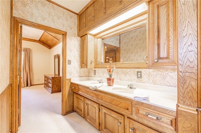 bathroom with crown molding, vanity, and lofted ceiling