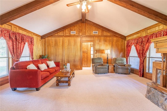 carpeted living room with beamed ceiling, high vaulted ceiling, ceiling fan, and wooden walls