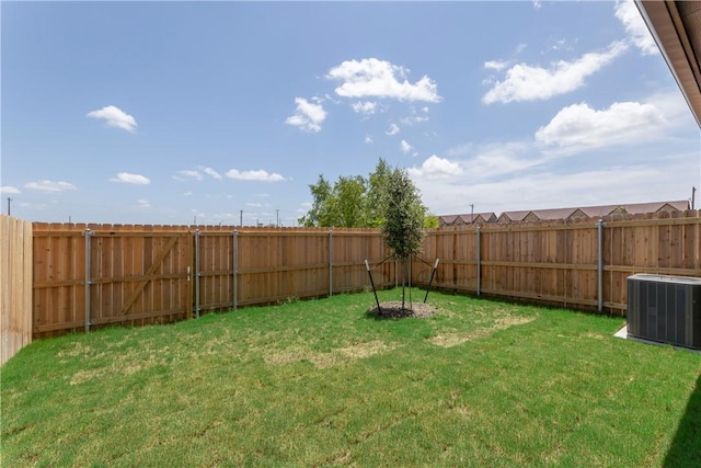 view of yard with central AC unit and a fenced backyard
