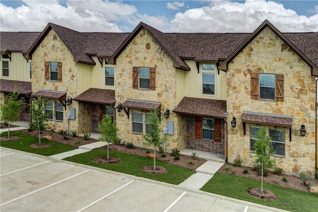 multi unit property with roof with shingles, board and batten siding, and stone siding