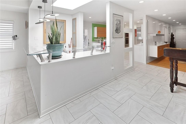 1013 Winding Rd, College Station, TX 77840 - kitchen with a skylight, decorative light fixtures, recessed lighting, light countertops, and baseboards