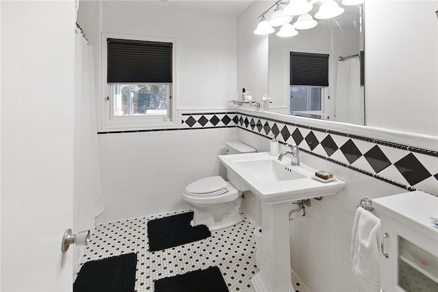 1013 Winding Rd, College Station, TX 77840 - full bath featuring toilet, a wainscoted wall, a shower with curtain, tile patterned floors, and tile walls