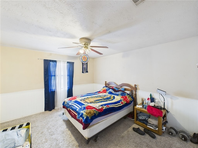 1008 Bittle Ln, Bryan, TX 77803 - carpeted bedroom featuring wainscoting, a textured ceiling, and a ceiling fan