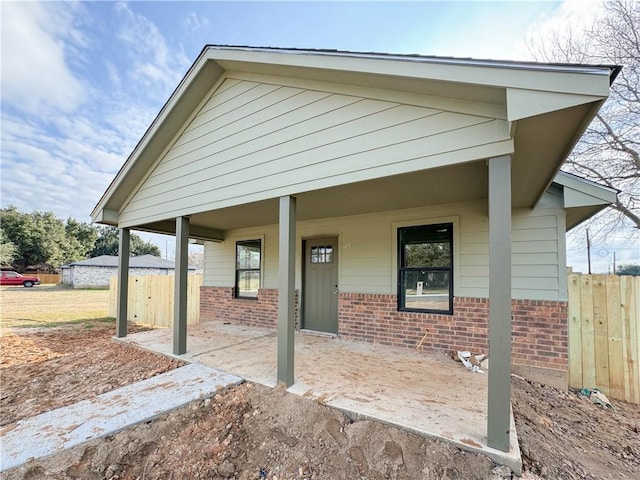 view of front of property with brick siding and fence